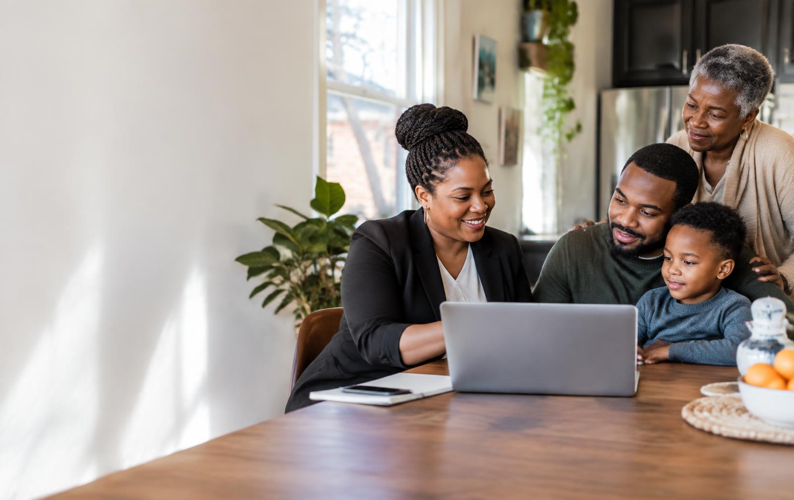 A Black financial educator helping a multigenerational Detroit family review resources at home.